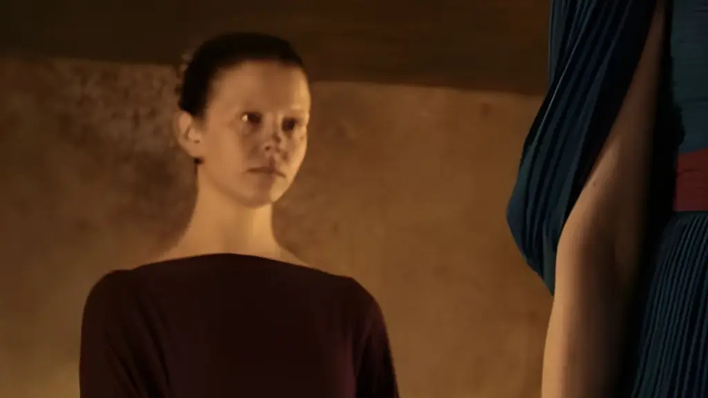 Mia Goth no papel da criada Melanto